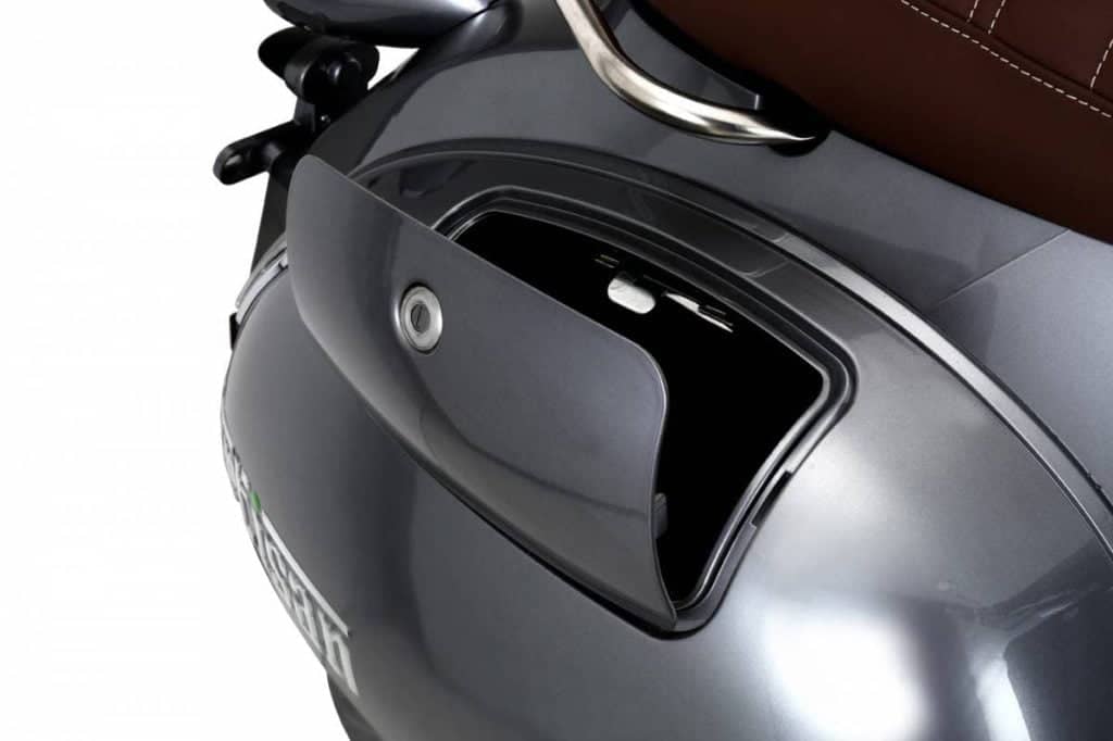 Lockable rear storage compartment on moped fender