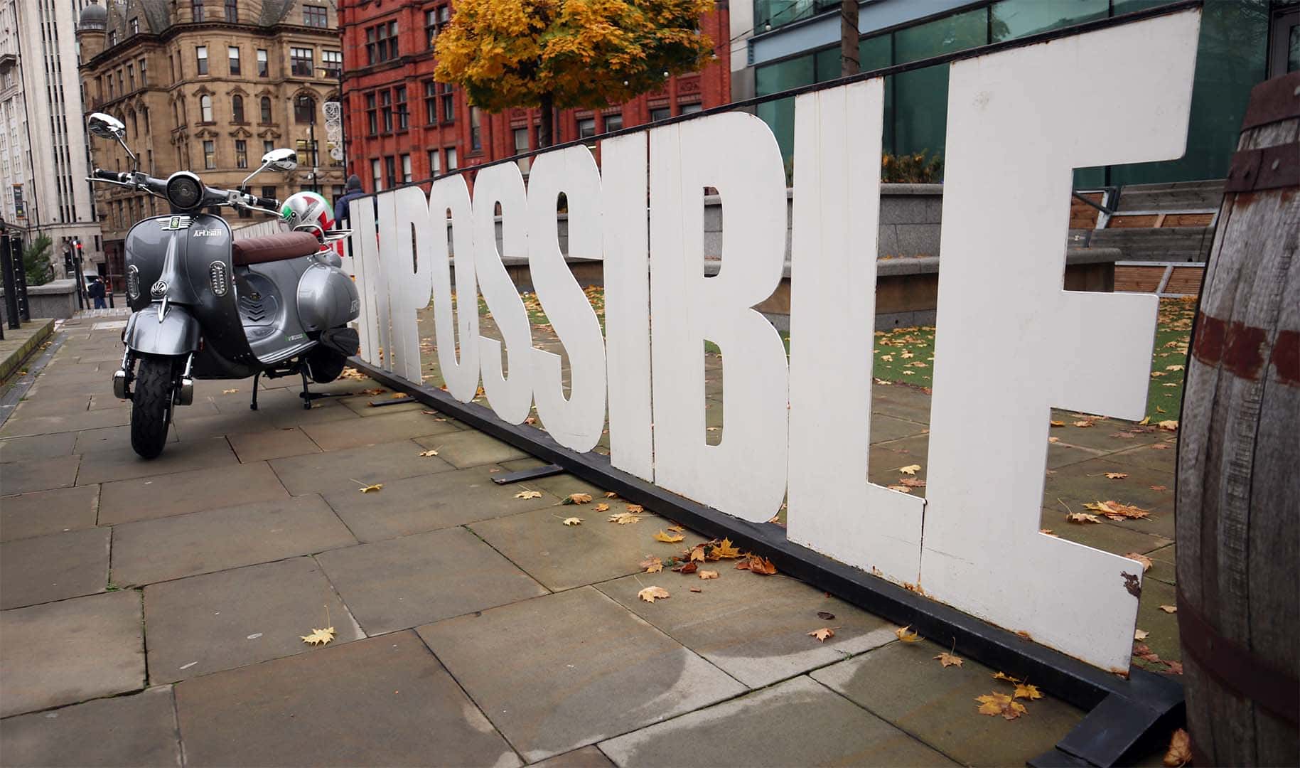 Artisan moped by sign saying impossible
