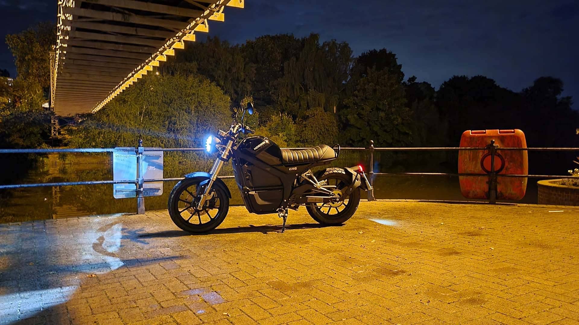 Horwin electric motorcycle next to a canal at night