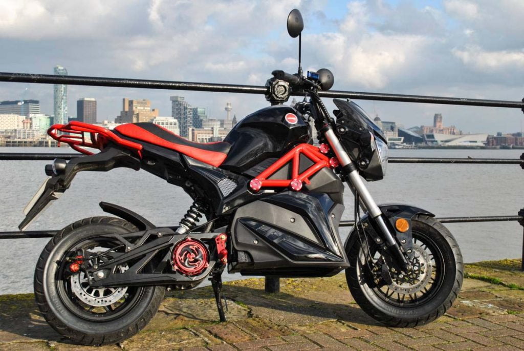 Red and black Ev0 electric motorcycle with Liverpool skyline